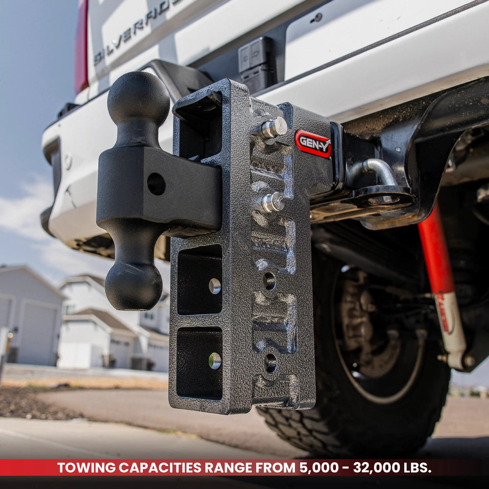 GEN-Y MEGA-DUTY adjustable drop hitch with dual-ball mount installed on a pickup truck, with a banner reading towing capacities range from 5,000 to 32,000 pounds